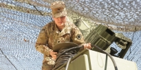 Soldier preforms preventative checks and maintenance on a satellite communication system.