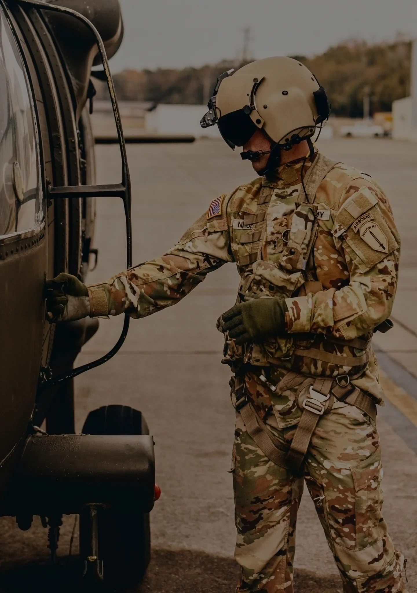 An Army pilot closing the door on a helicopter